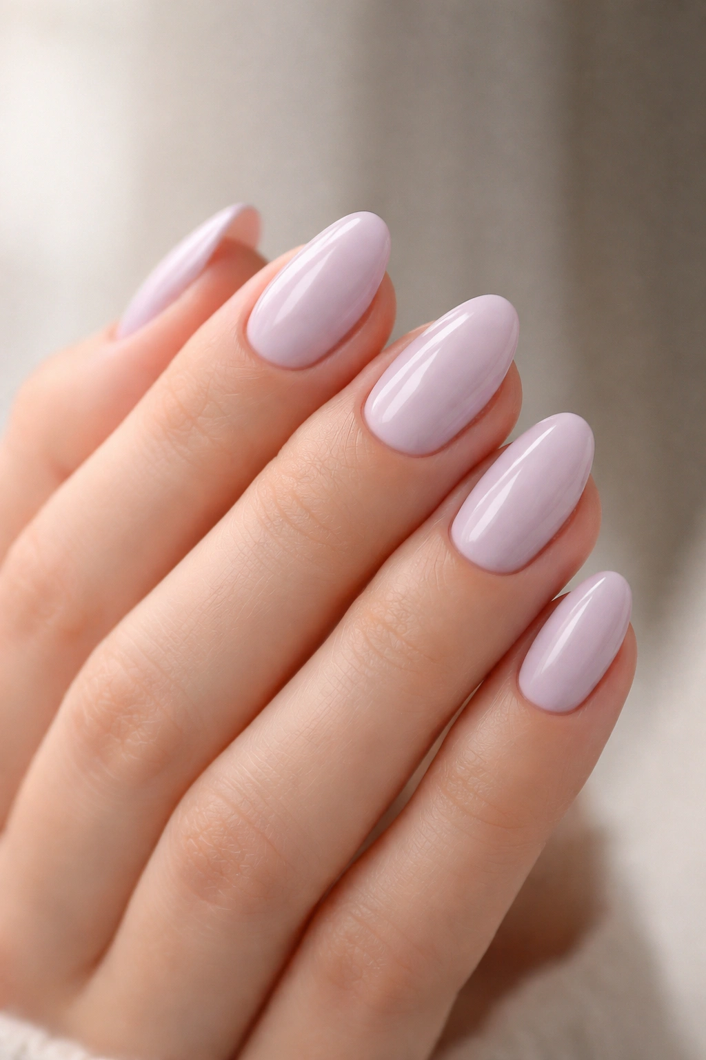 Close-up of pale lilac almond nails on hand