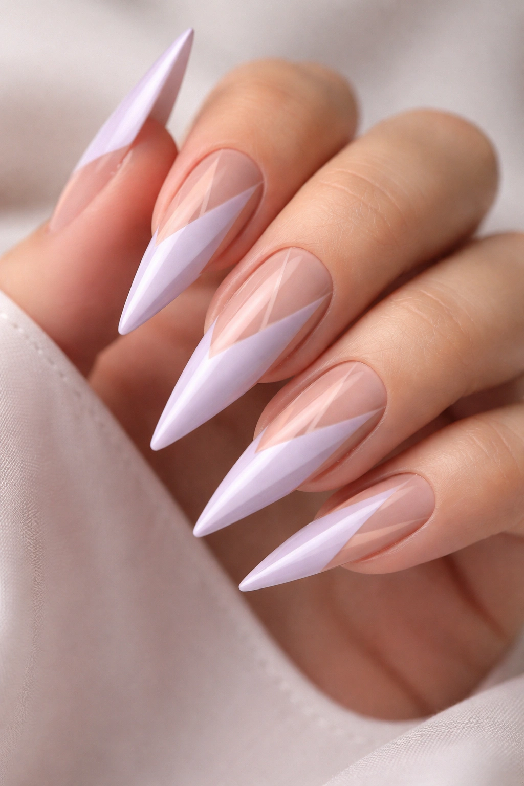 Close-up of pale lilac nails with geometric negative-space patterns