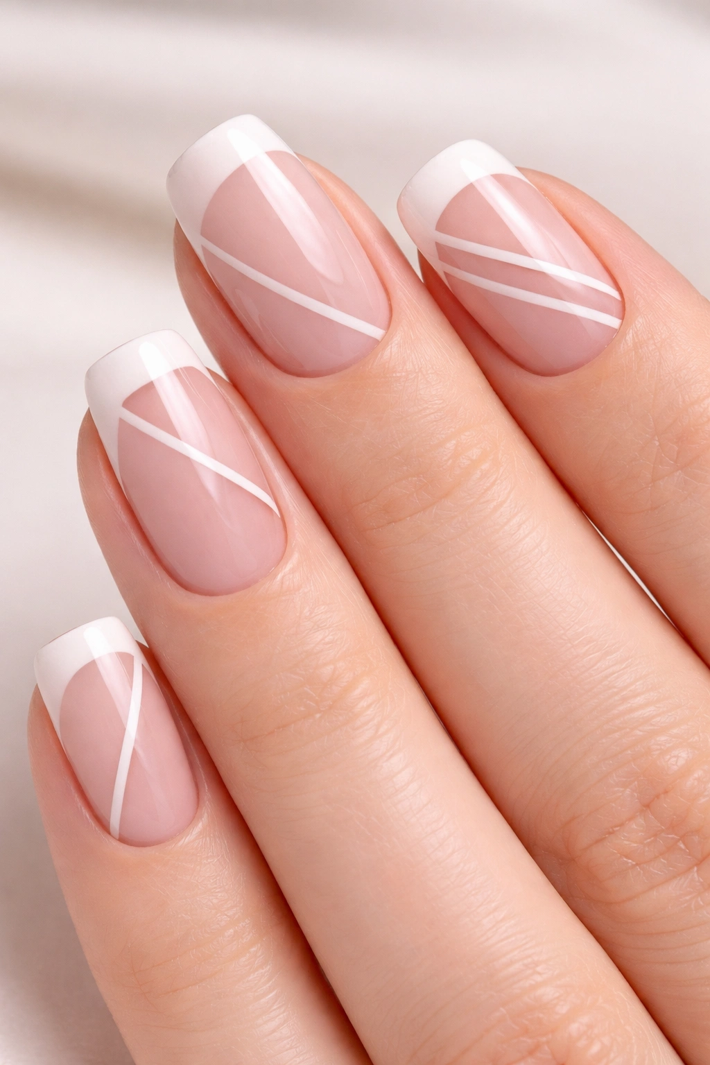 Pale pink nails with negative-space geometric patterns