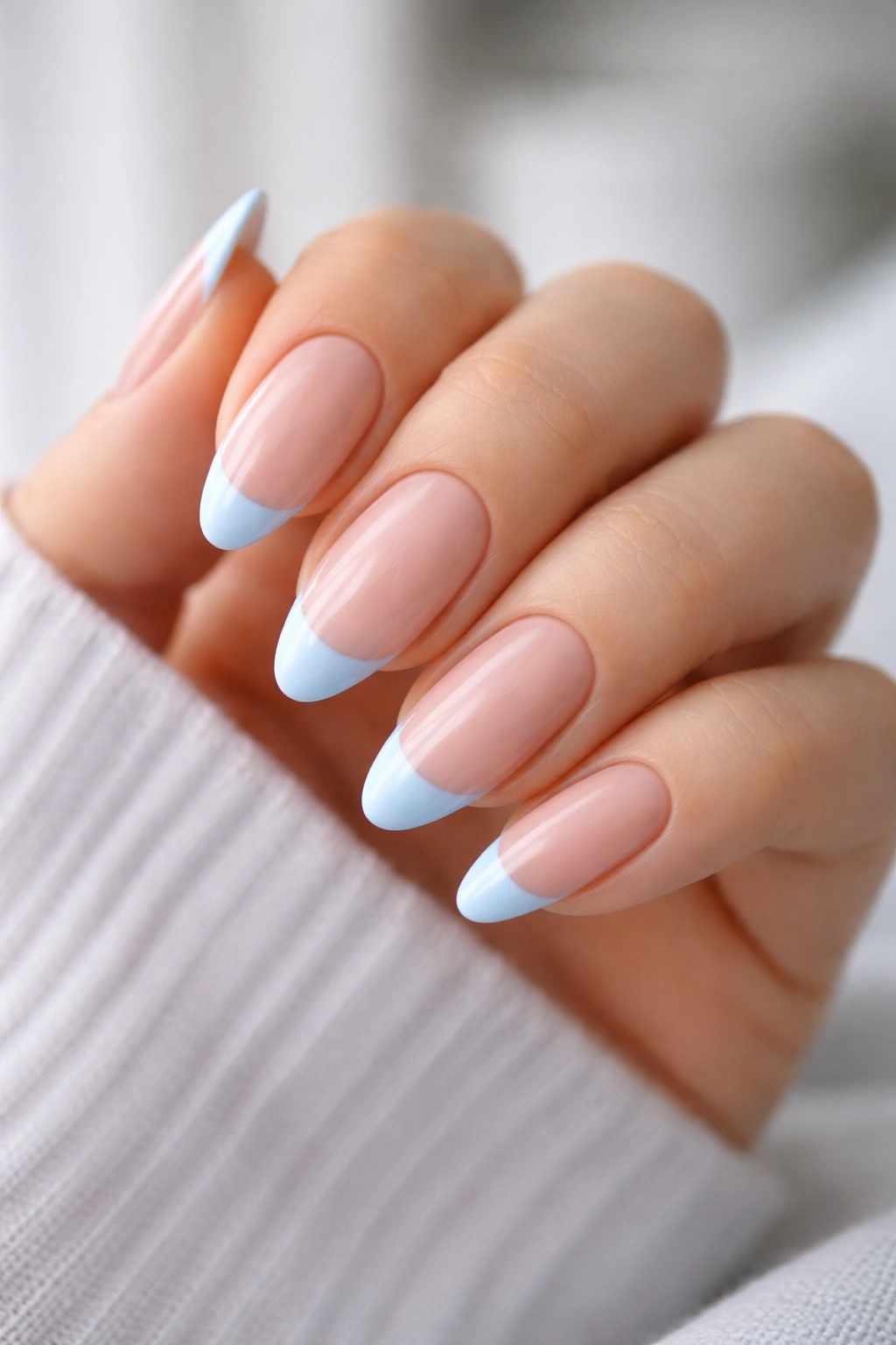 Almond nail with pastel blue tip on nude base