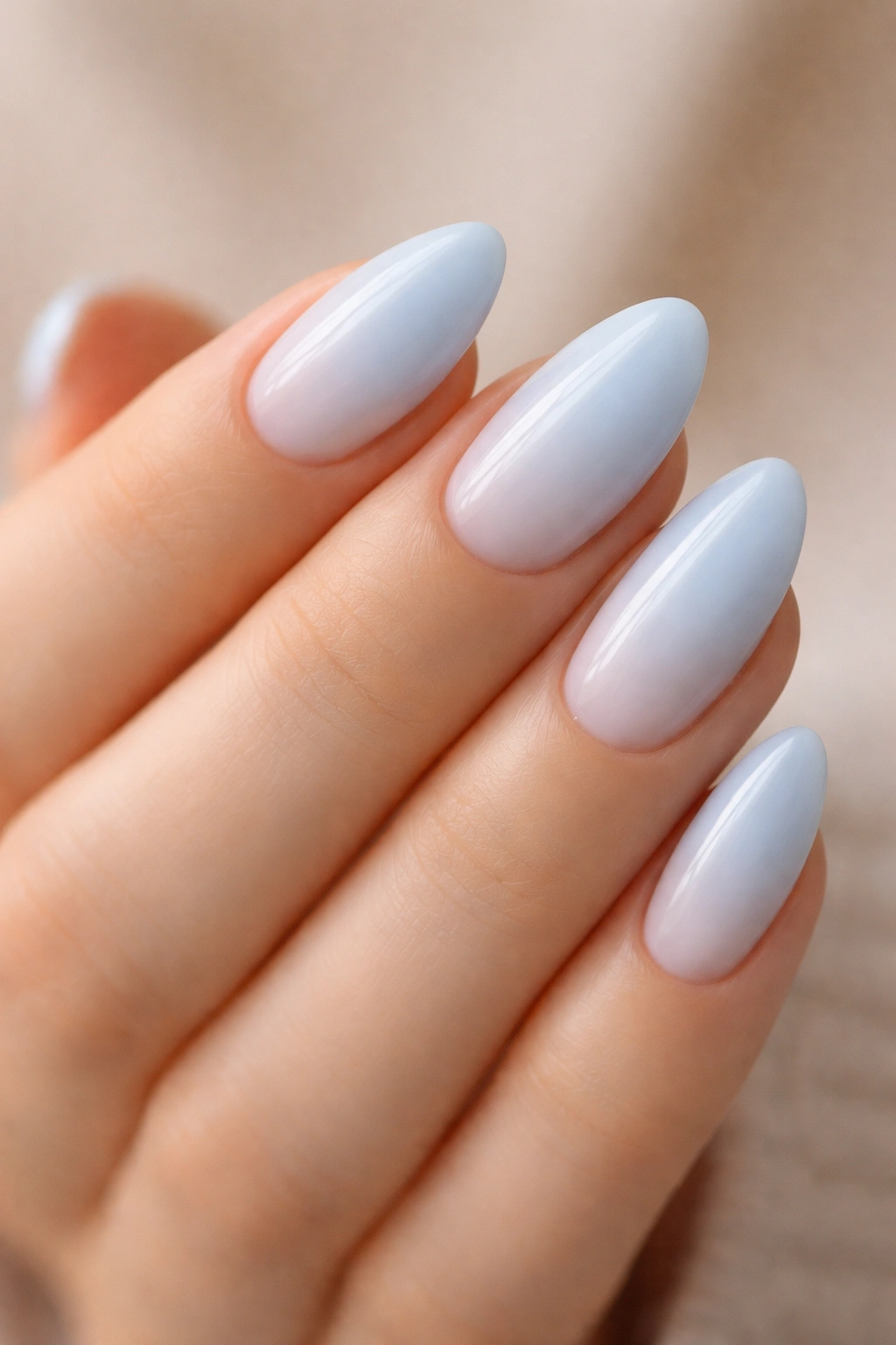 Close-up of pastel blue almond nails with a milky base for a soft, airy look.