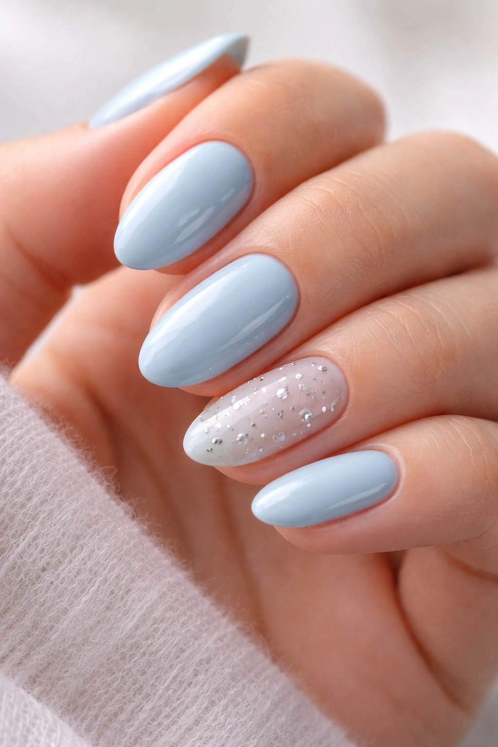 Close-up of short almond nails pastel blue with silver star accents