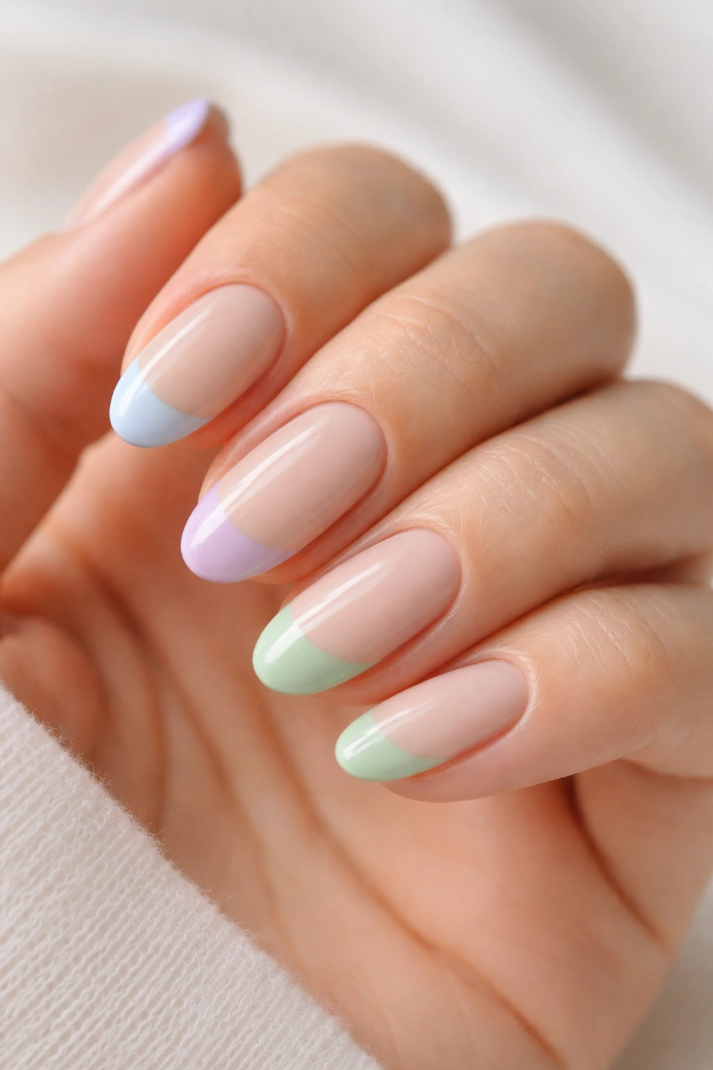 Close-up of short almond nails with pastel blue lilac or sage tips