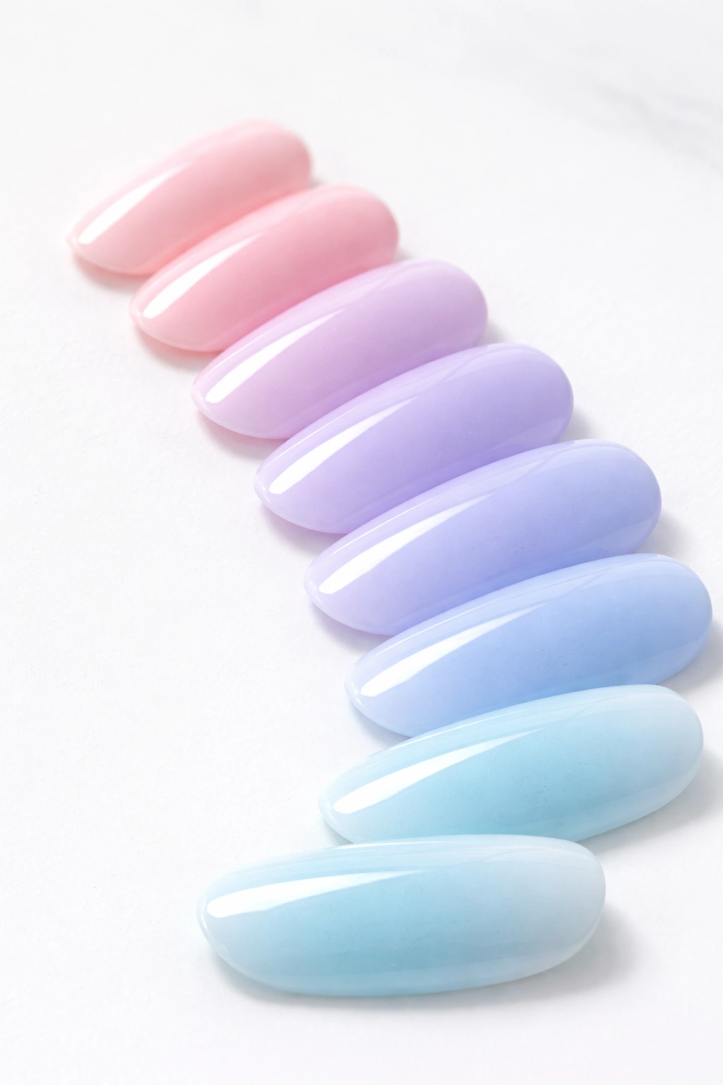 Close-up of pastel color swatches blending from pink to lilac to blue on a clean surface