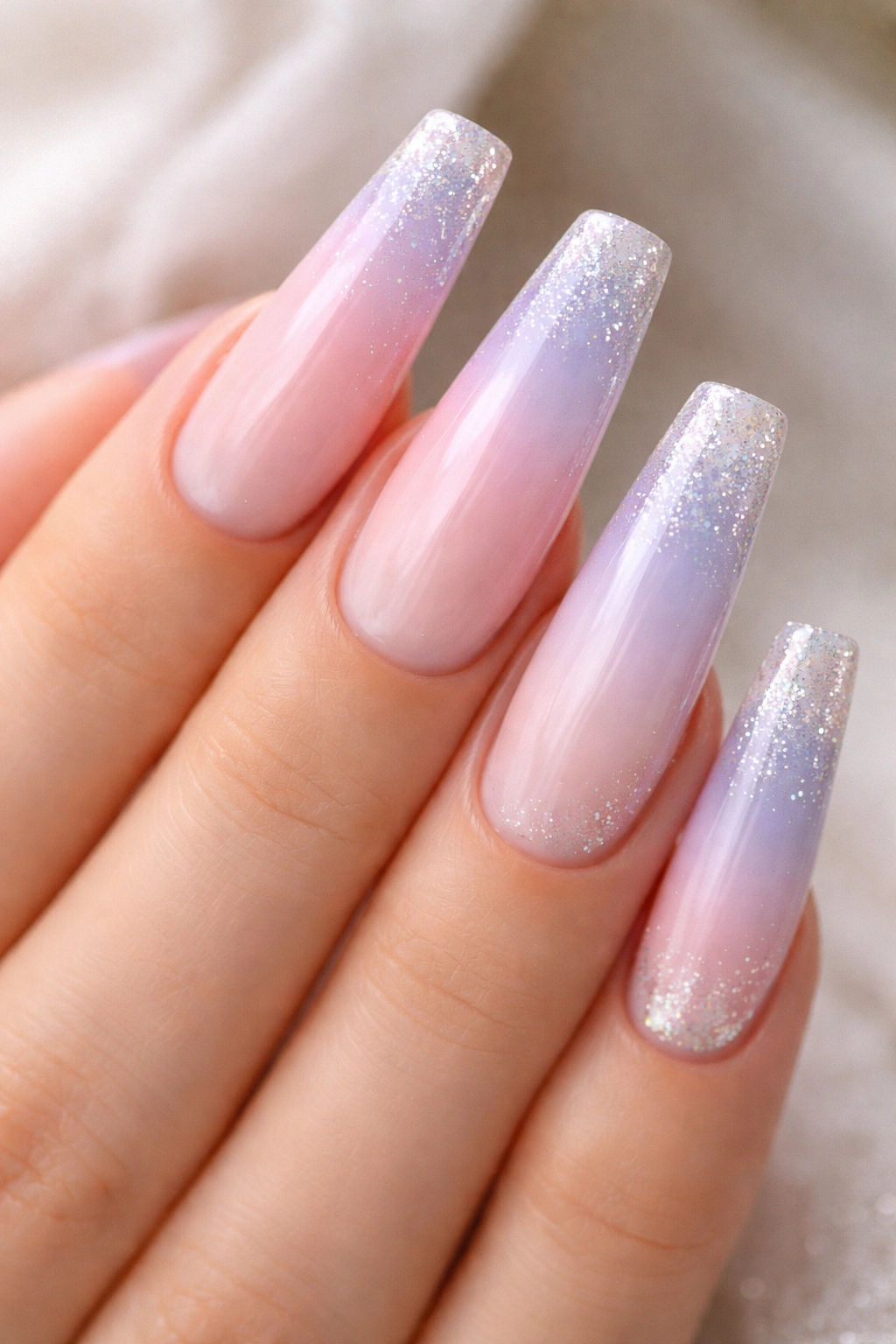 Close-up of pastel gradient coffin nails with glitter tips