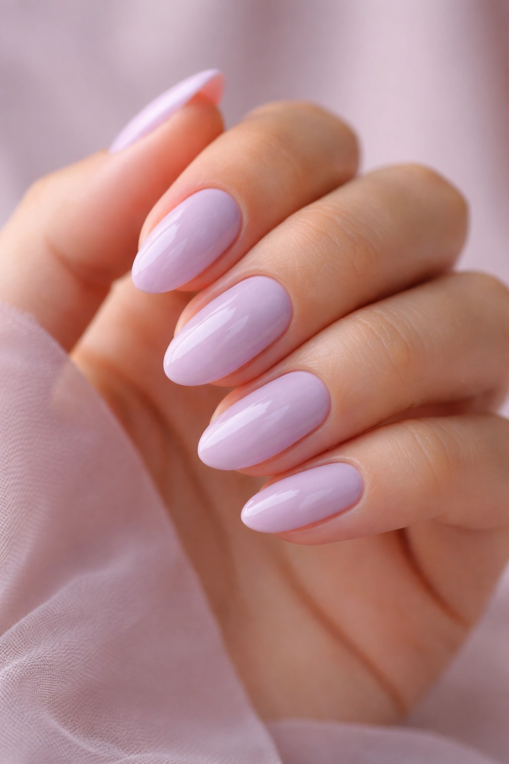Close-up of short almond nails in pastel lavender with glossy finish