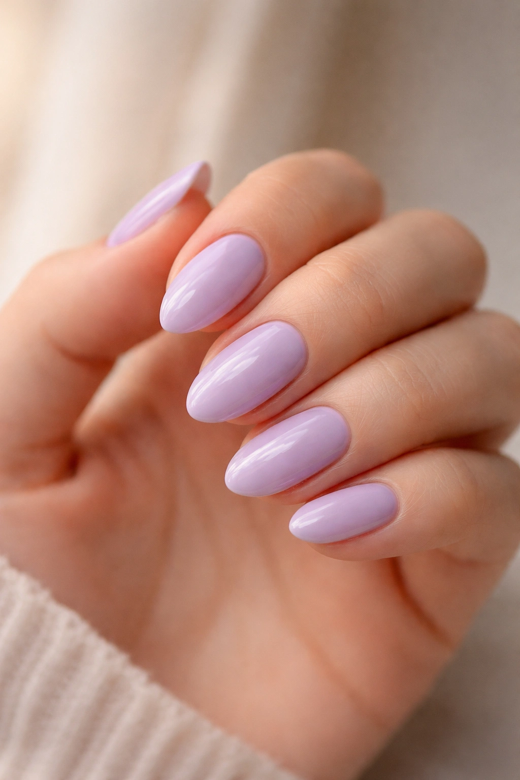 Close-up of short almond nails in muted lavender pastel with glossy finish