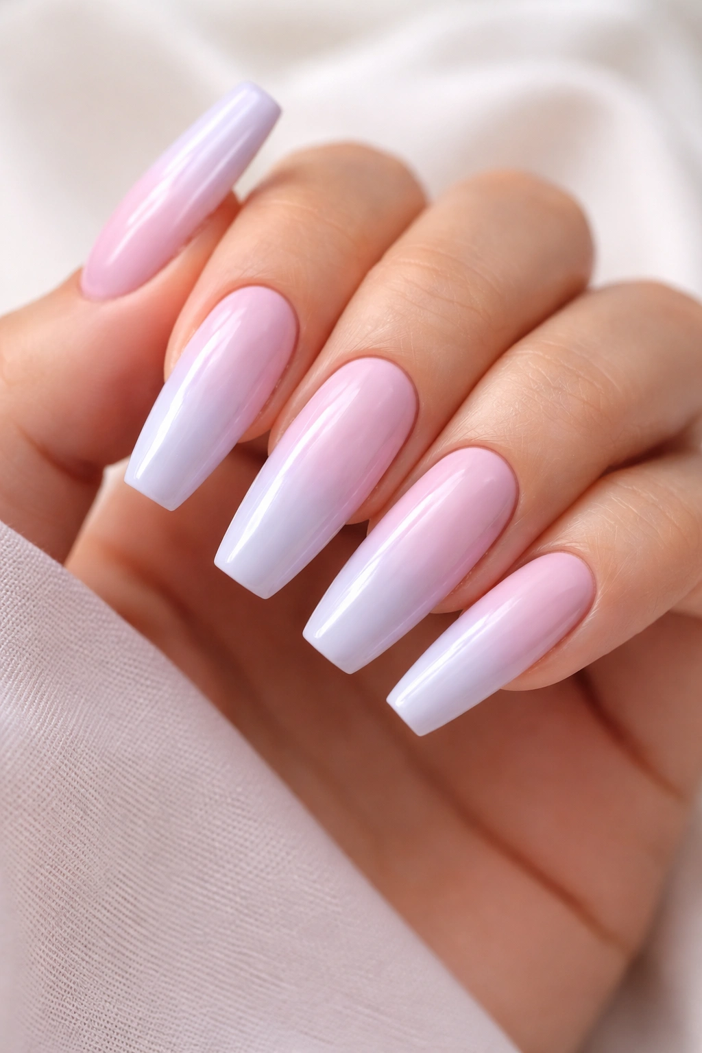 Close-up of pastel ombre coffin nails blending two soft pastel shades on a neutral background