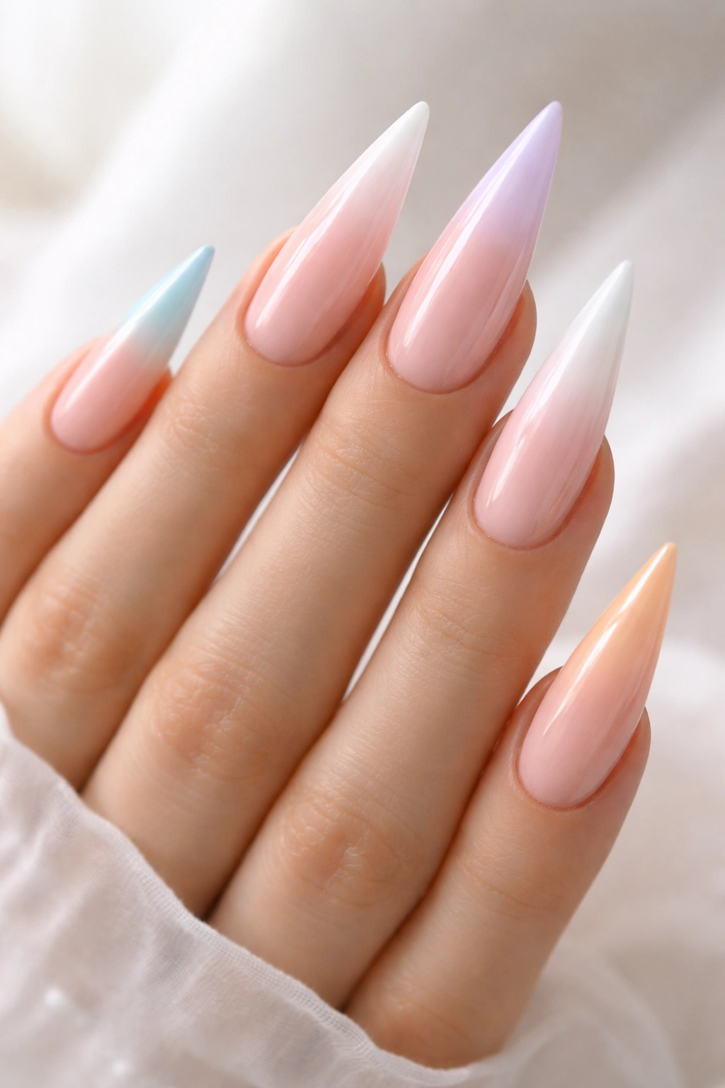 Stiletto nails with pastel ombré French tips on a pale base