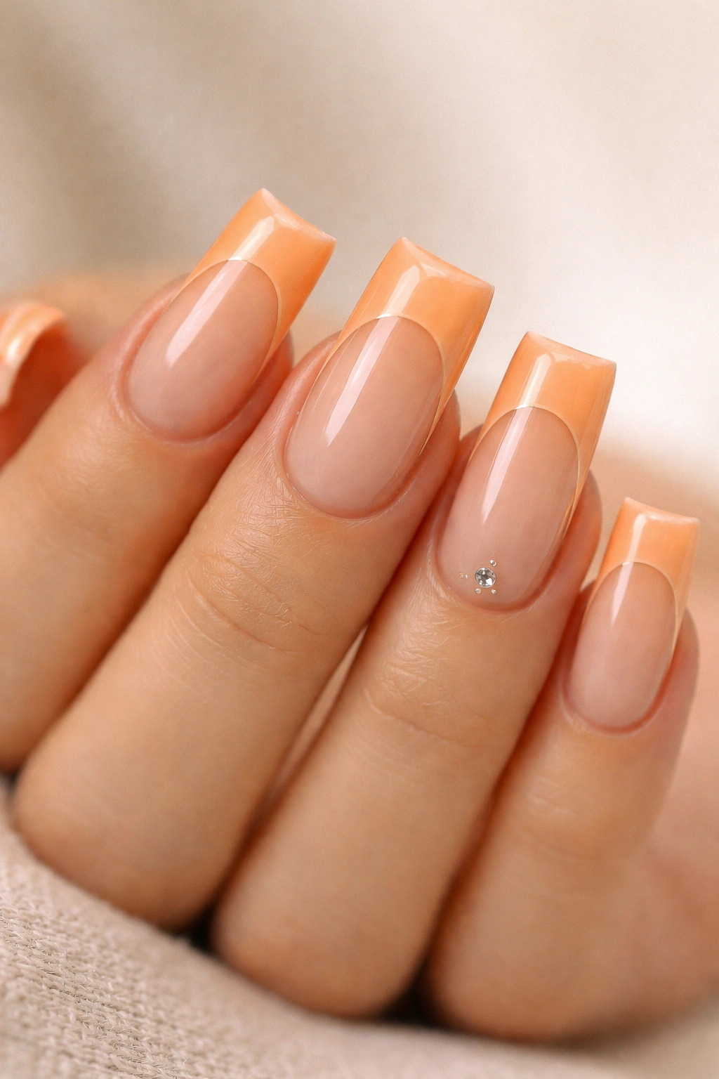Close-up of pastel orange duck nails with soft nude details