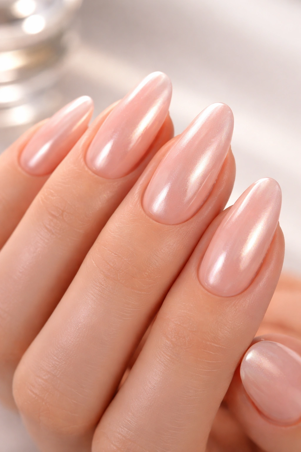 Close-up of peach nails with glazed chrome iridescent finish