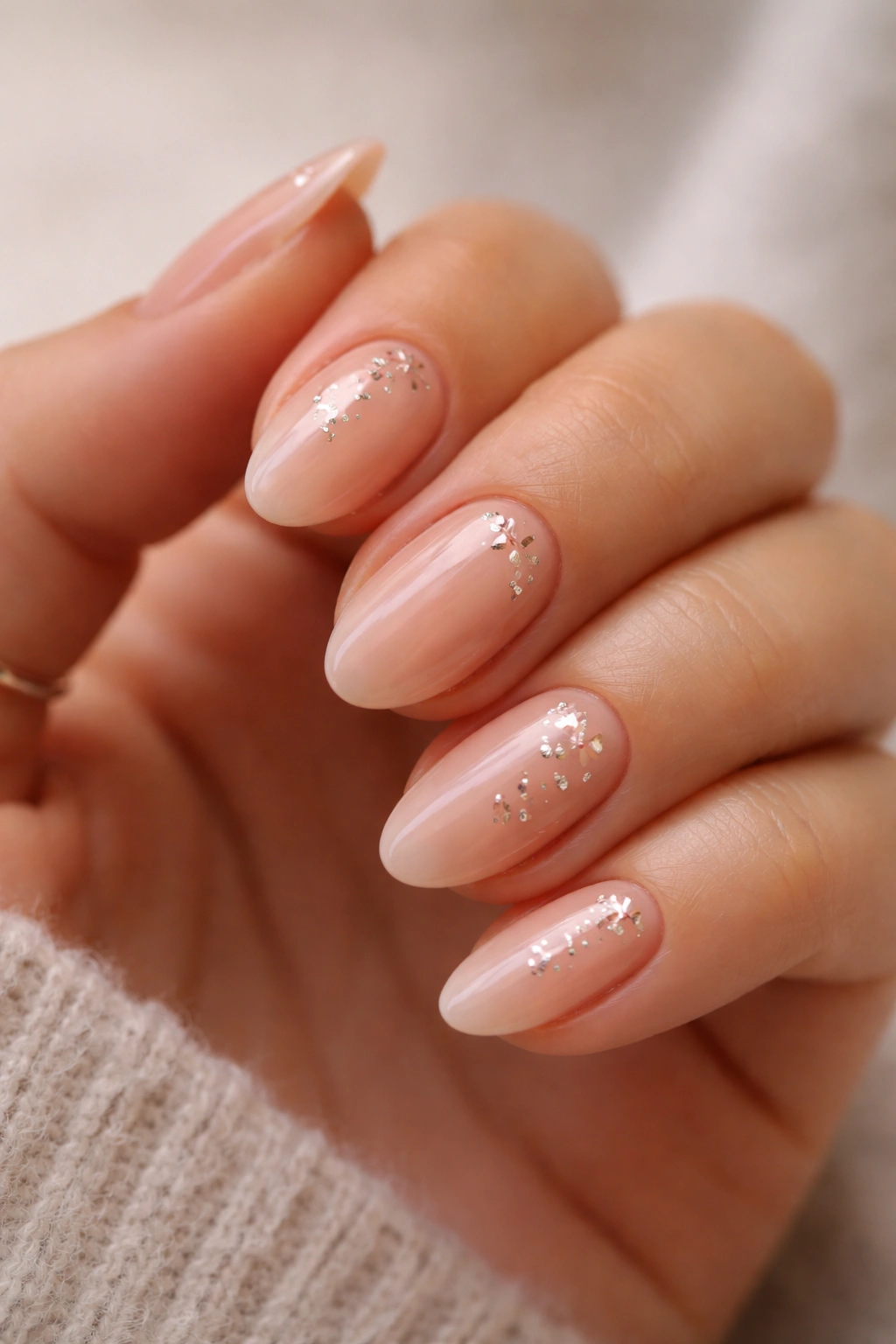 Close-up of peachy nude almond nails with rose gold star decals