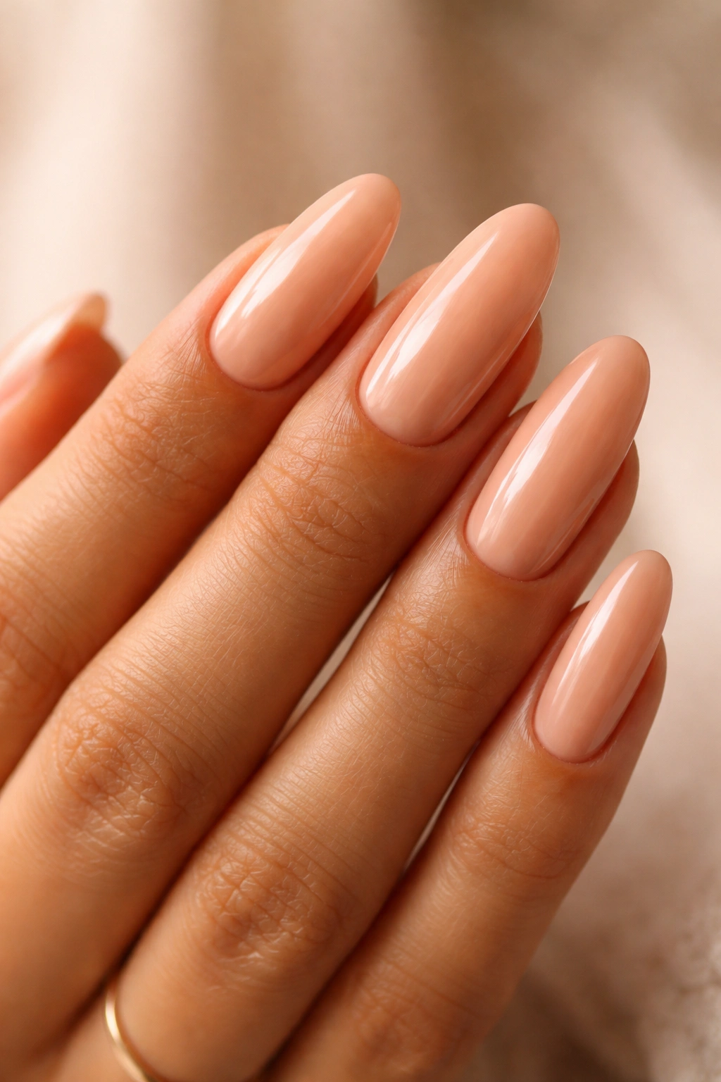 Long oval nails in peach-tea nude with glossy finish