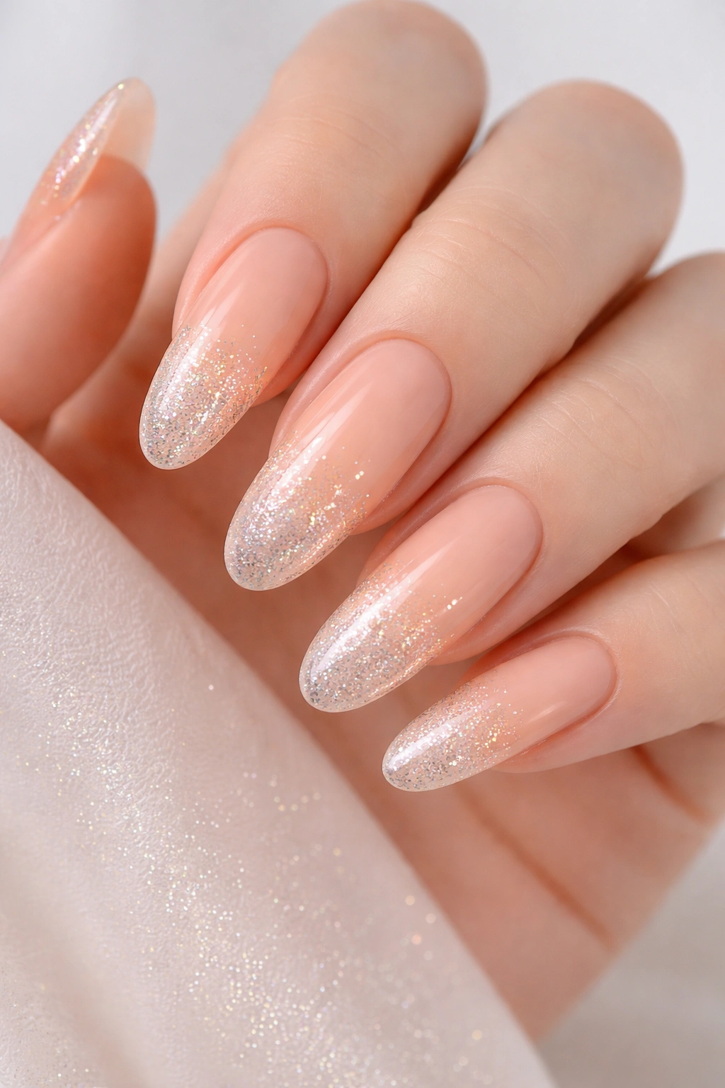 Peachy beige ombré nails with sparkle gradient on long ovals