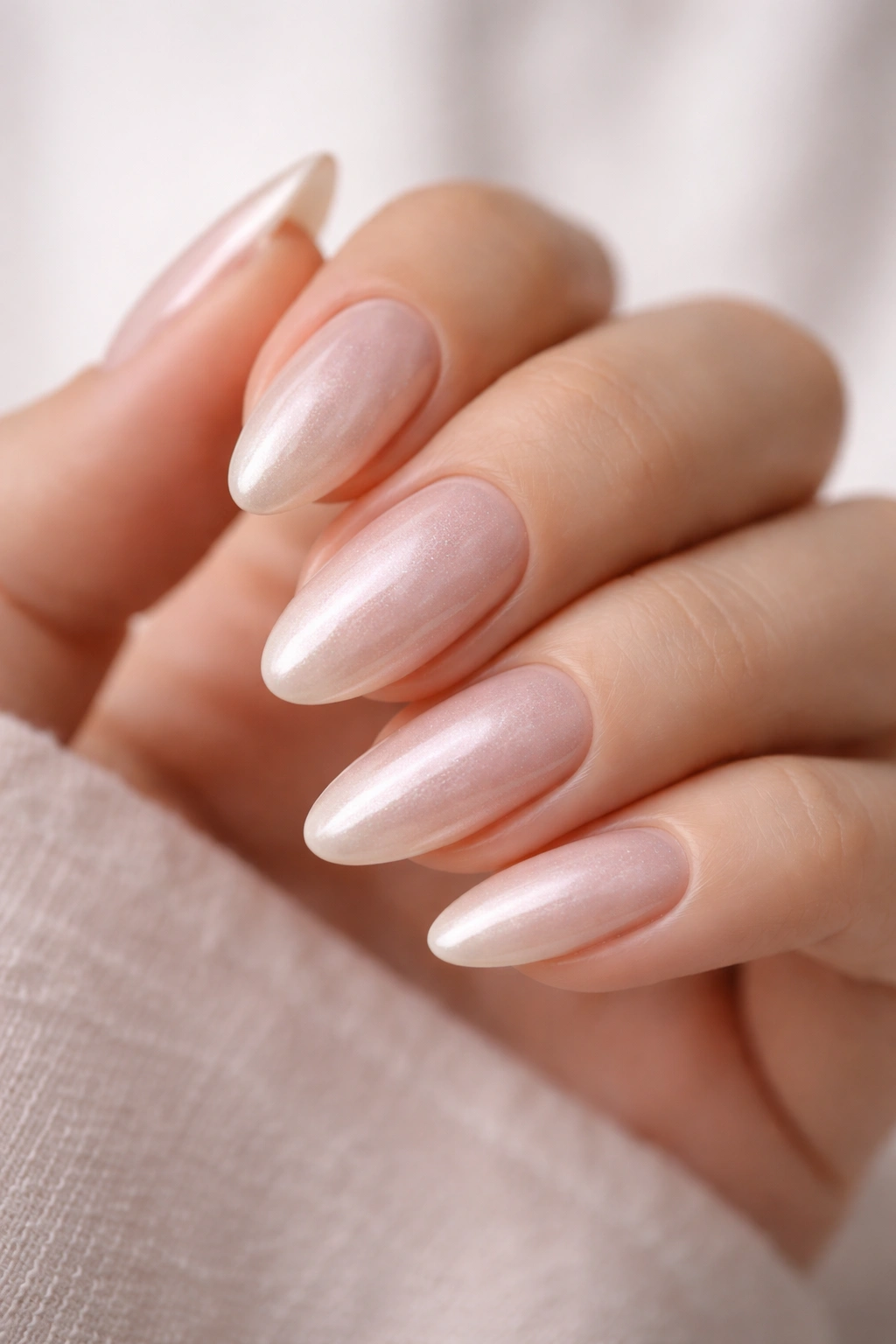 Pearl sheen almond-shaped nails with soft iridescent glow