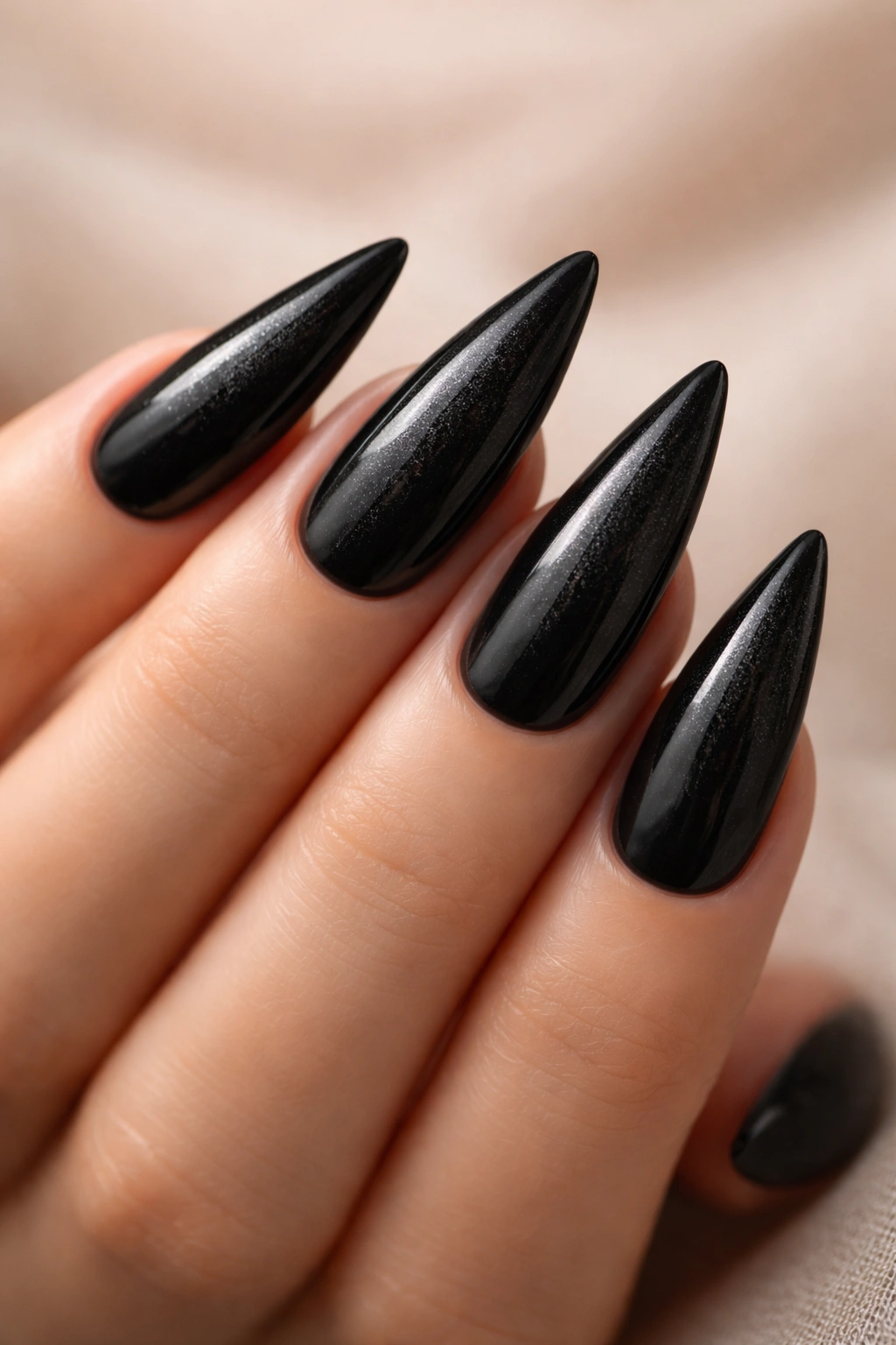 Black stiletto nails with subtle pearl dust shimmer