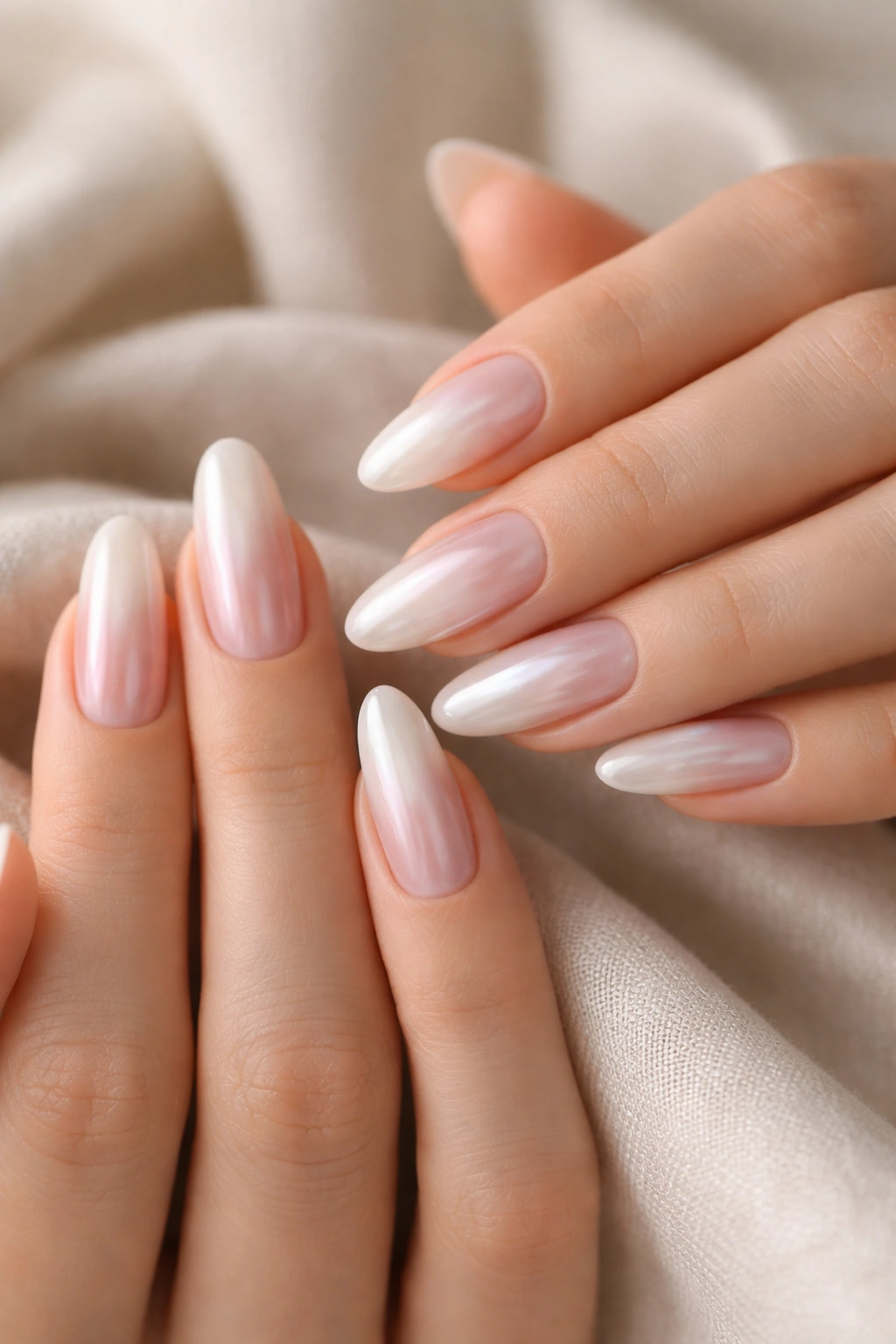 Close-up of tapered oval nails with pearlescent glaze on a nude base