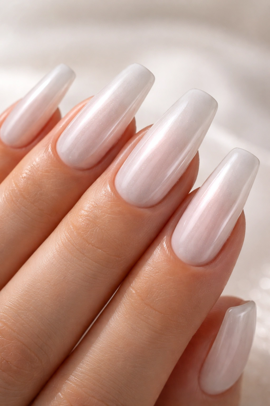 Milky white nails with pearl glaze and soft sheen on ballerina shape