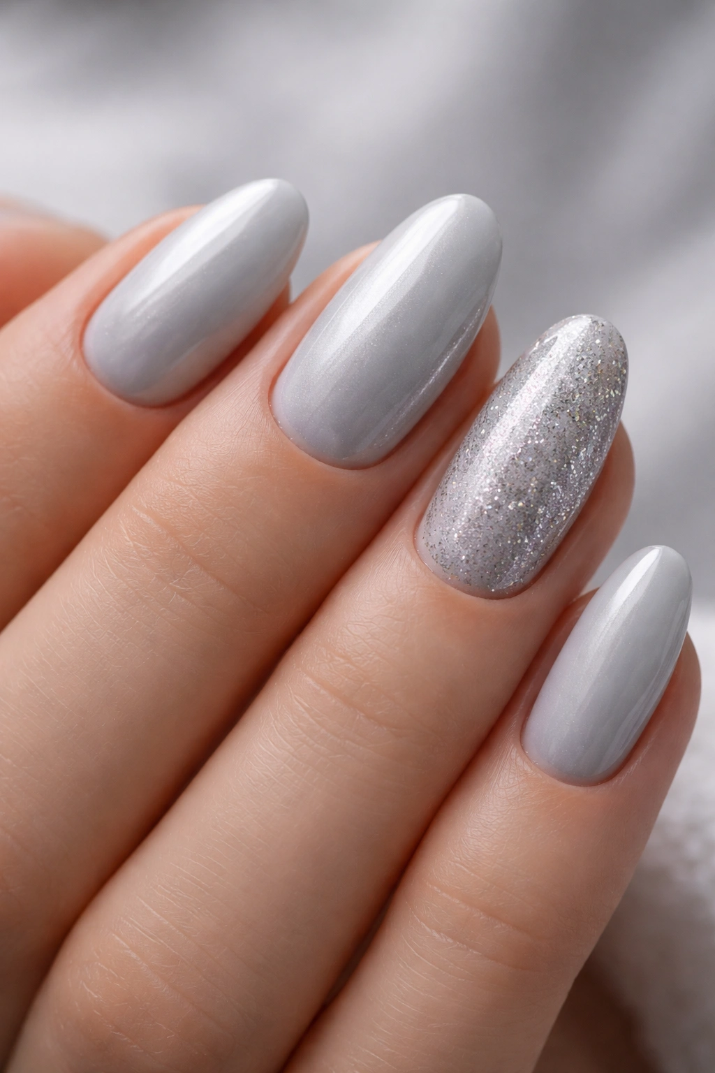 Nails in pearl grey with silver glitter accents on selected nails