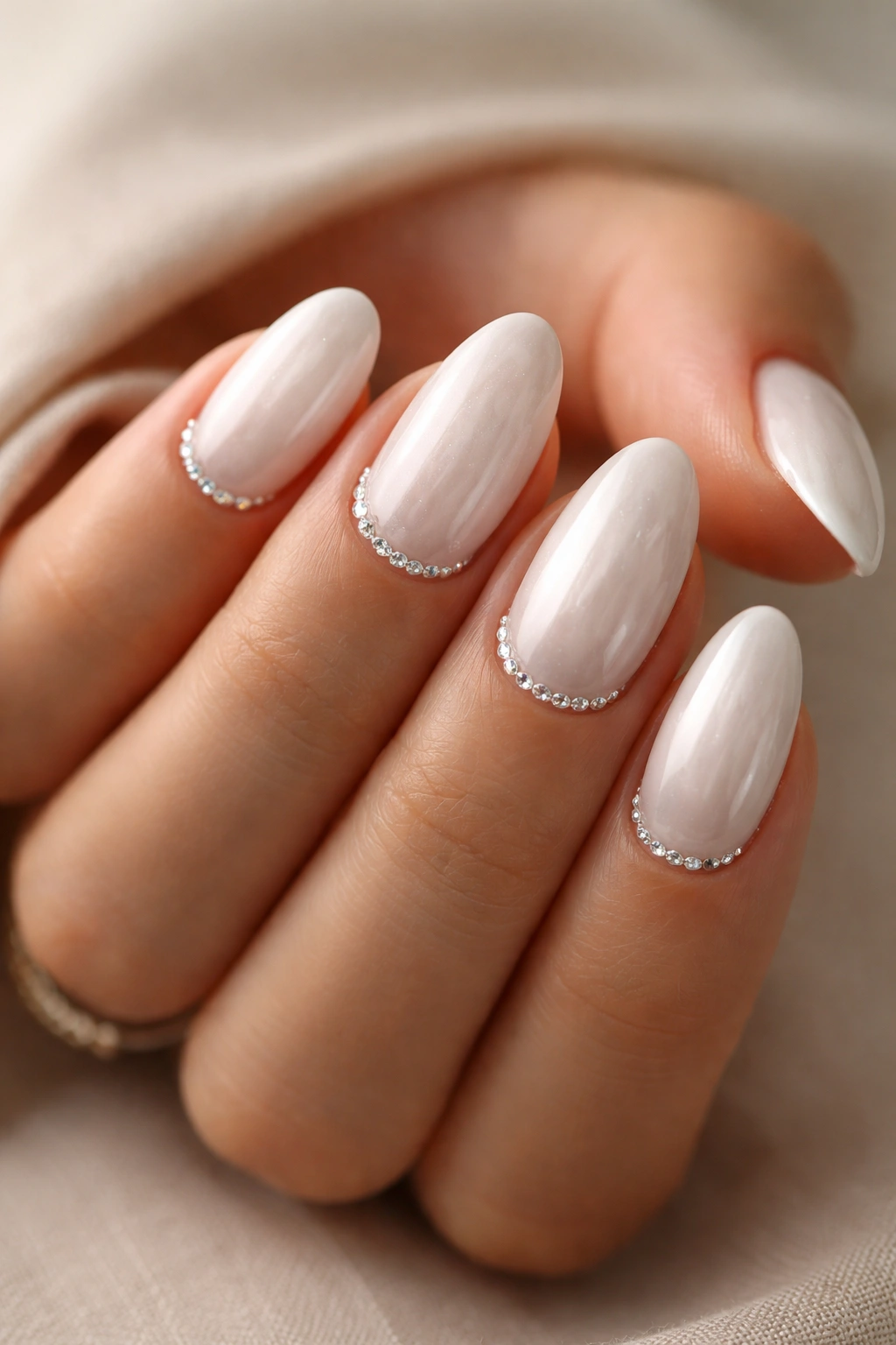 White pearl almond nails with tiny crystal cuticles on short nails
