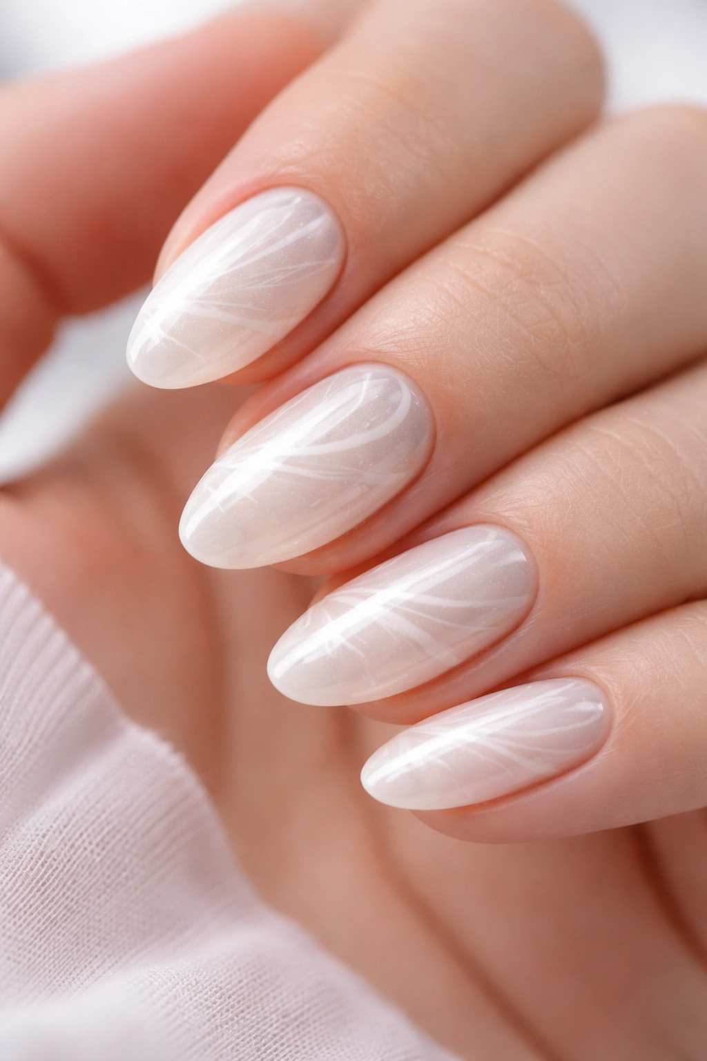 Short almond nails with white pearl base and subtle marble swirl