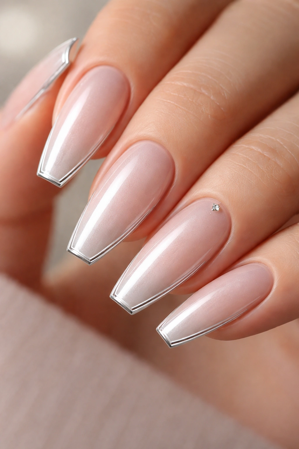 Pearl nude nails with a thin silver outline