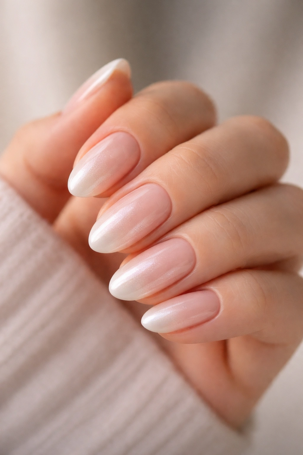 Close-up of pearl ombré almond nails with nude to pearl gradient