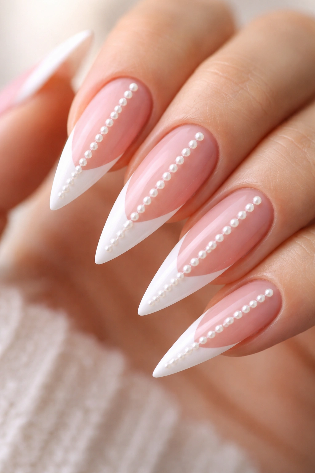Close-up of stiletto nails with a vertical pearl stripe on the white tip
