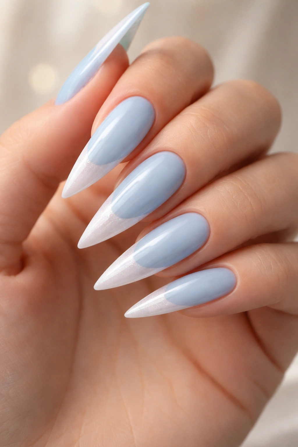 Stiletto nails with baby blue base and pearl white tips.