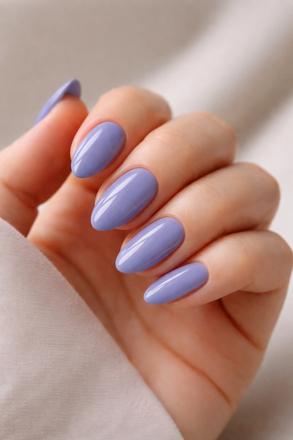 Close-up of short almond nails in periwinkle with a glossy finish.