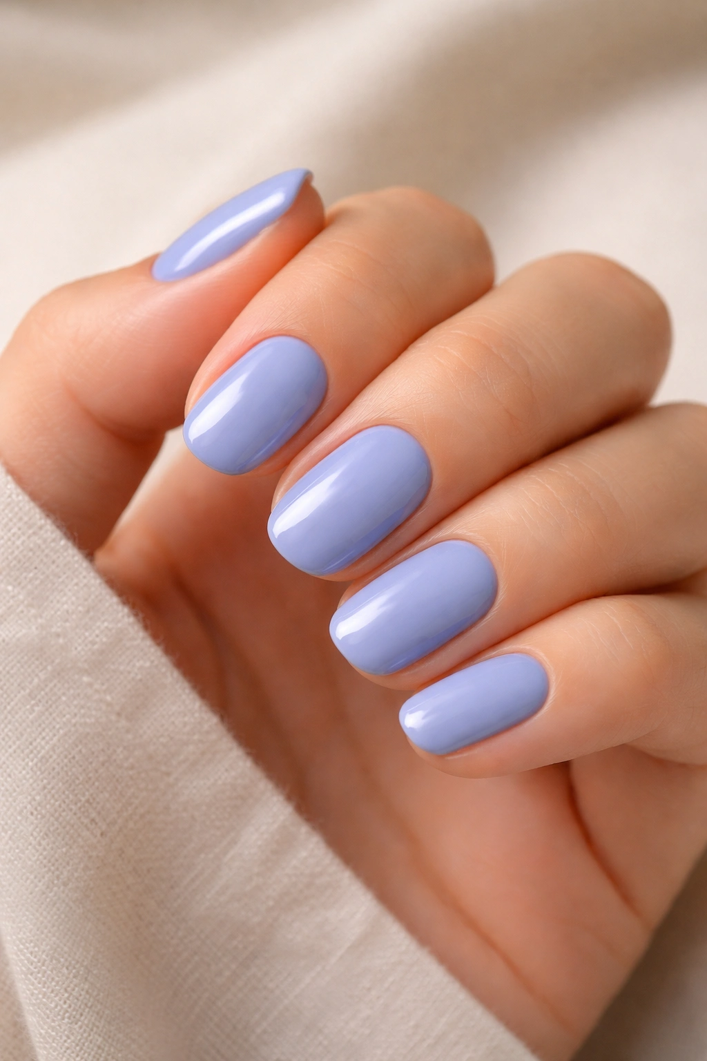 Close-up of periwinkle short oval nails with glossy finish