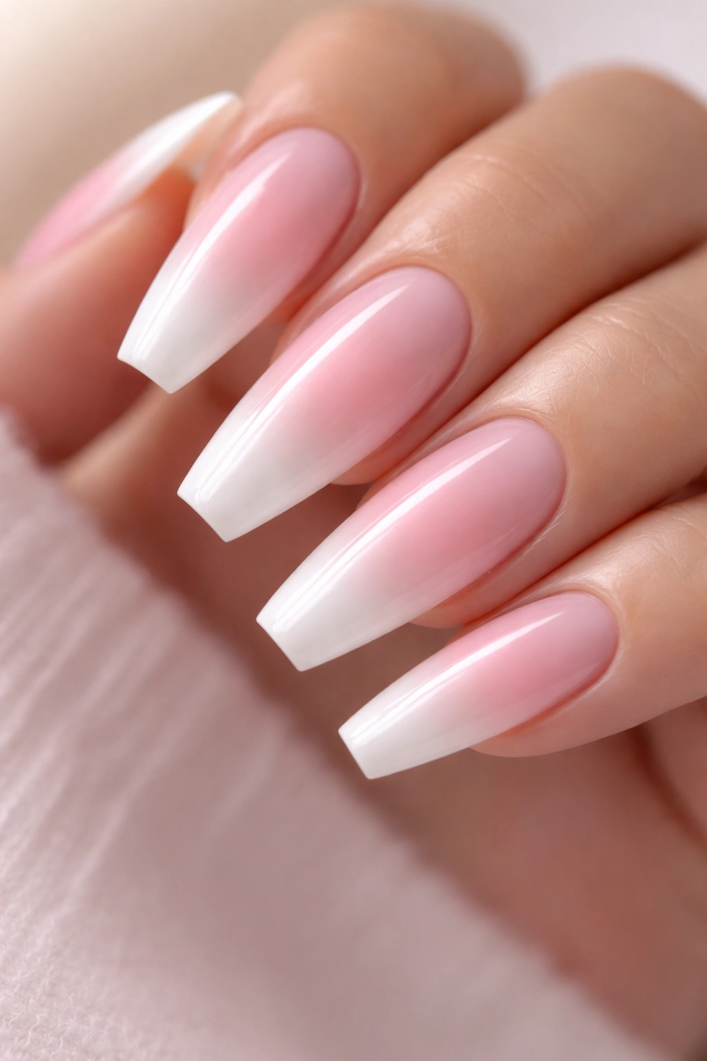 Close-up of pink aura center ballerina nails with a soft white halo and glossy finish