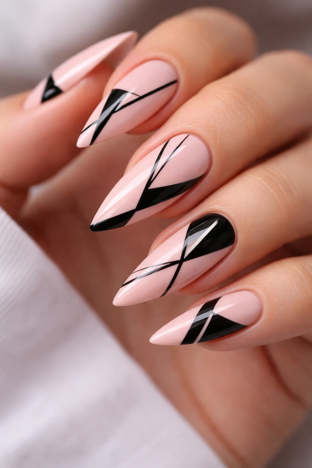 Close-up of pink nails with black geometric shapes