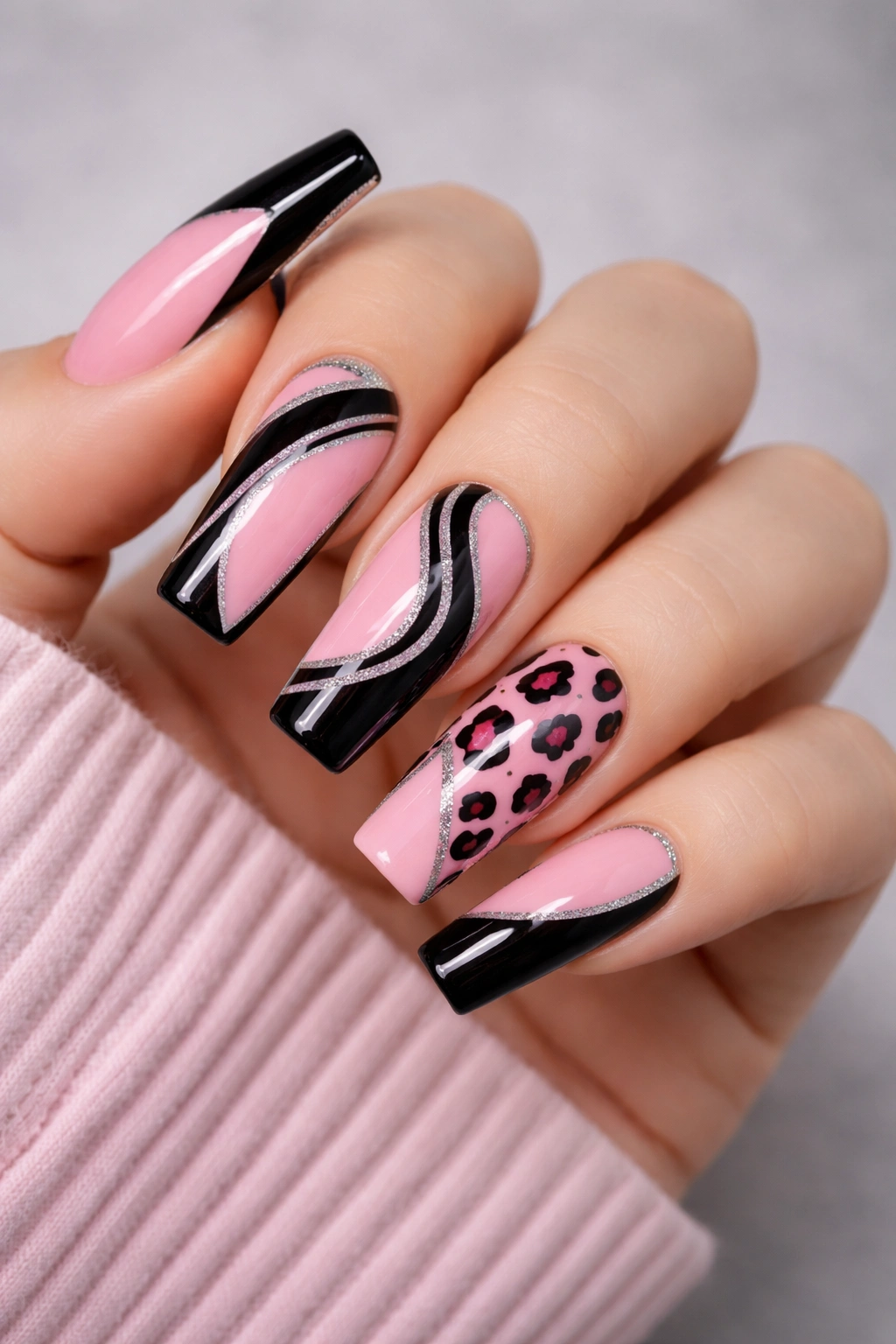 Close-up of pink and black nails with bold geometric accents