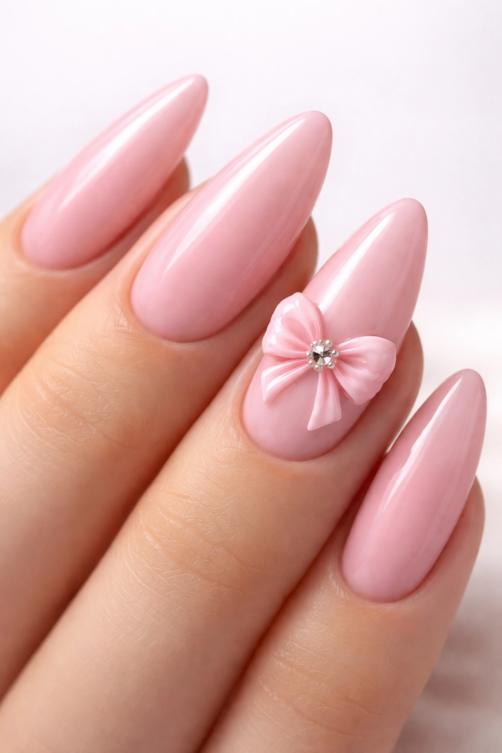 Close-up of pink bow nail art on almond nail