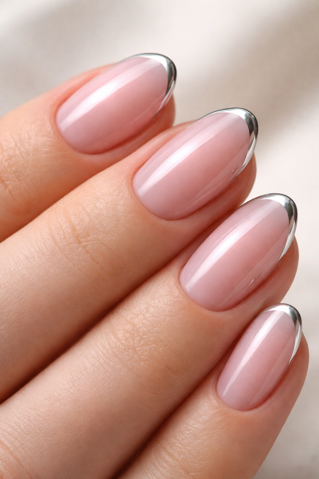 Close-up of a short almond nail with sheer pink base and ultra-thin chrome tip line