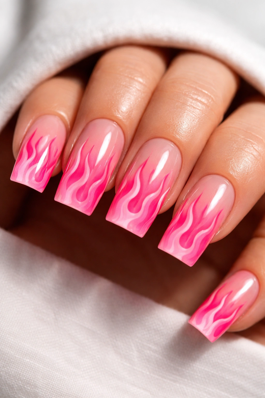 Close-up of short square acrylic nails with pink flame nail art