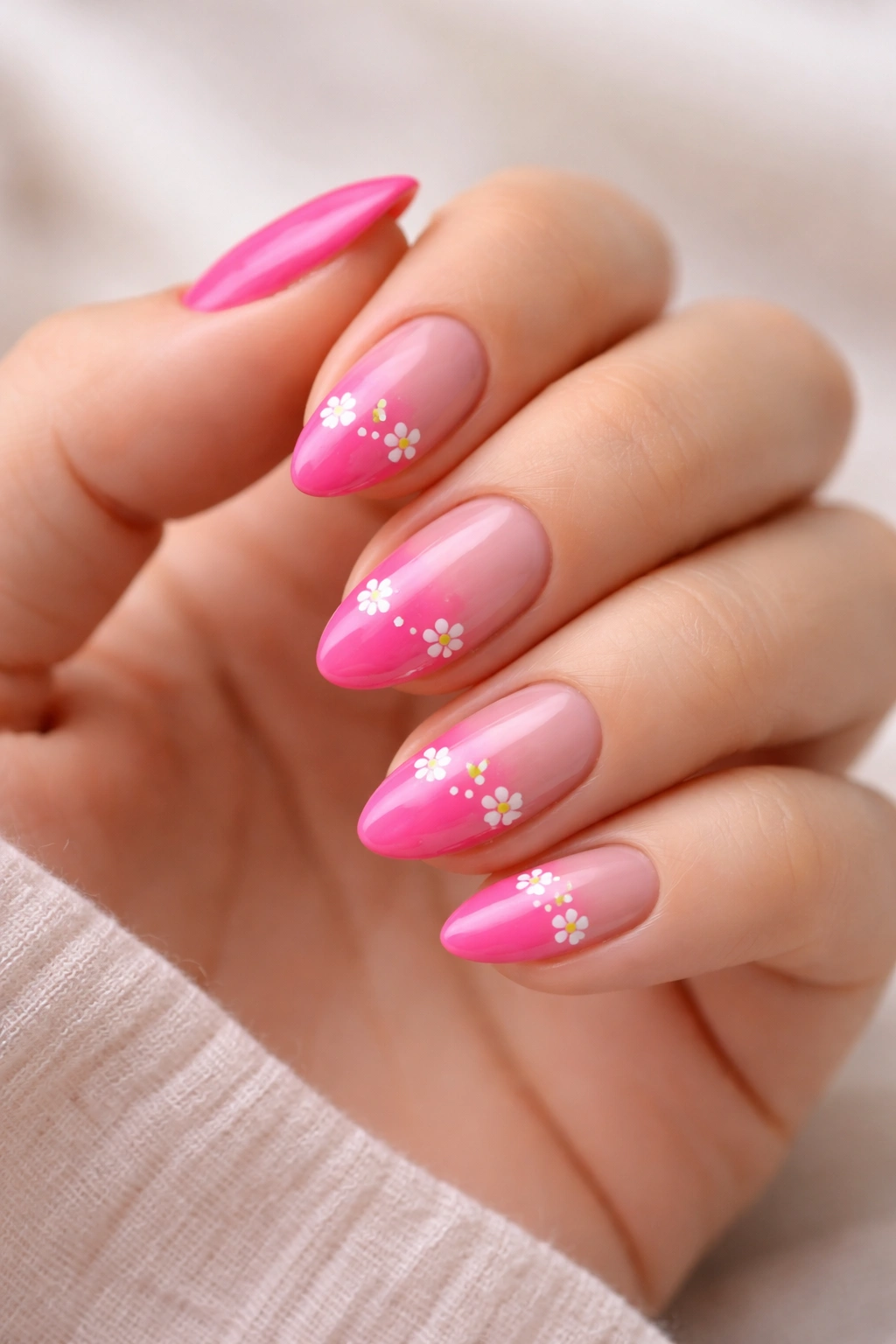 Close-up of hot pink almond nails with tiny floral accents