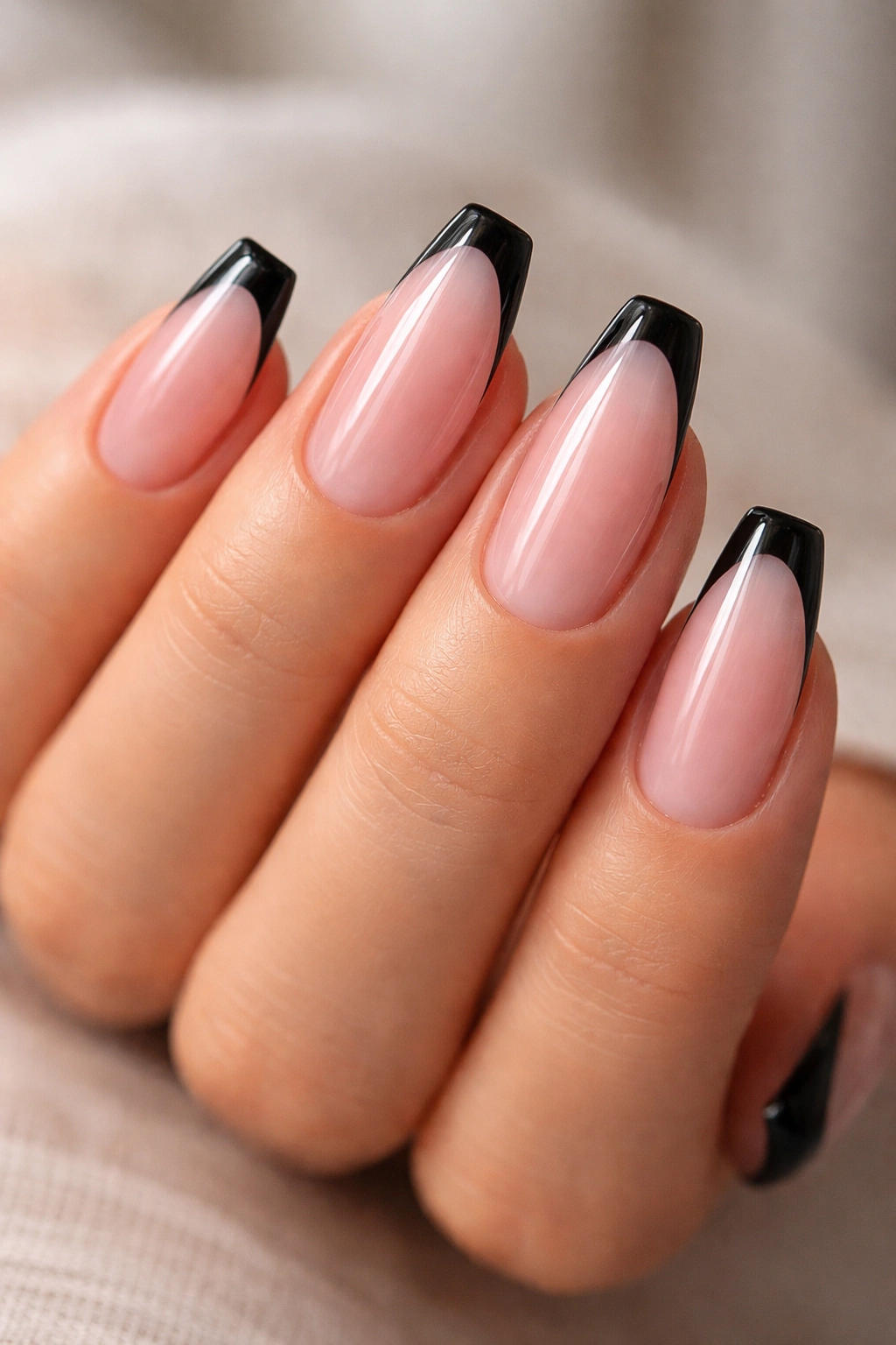 Close-up of nails with sheer pink jelly base and slim black corners