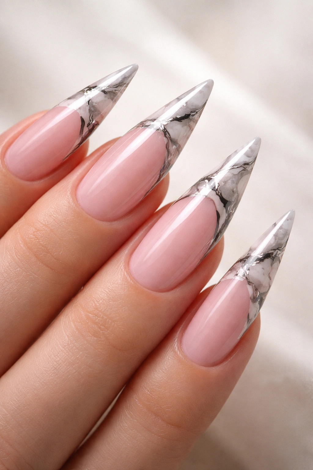 Pink stiletto nails with marble accents on the tips