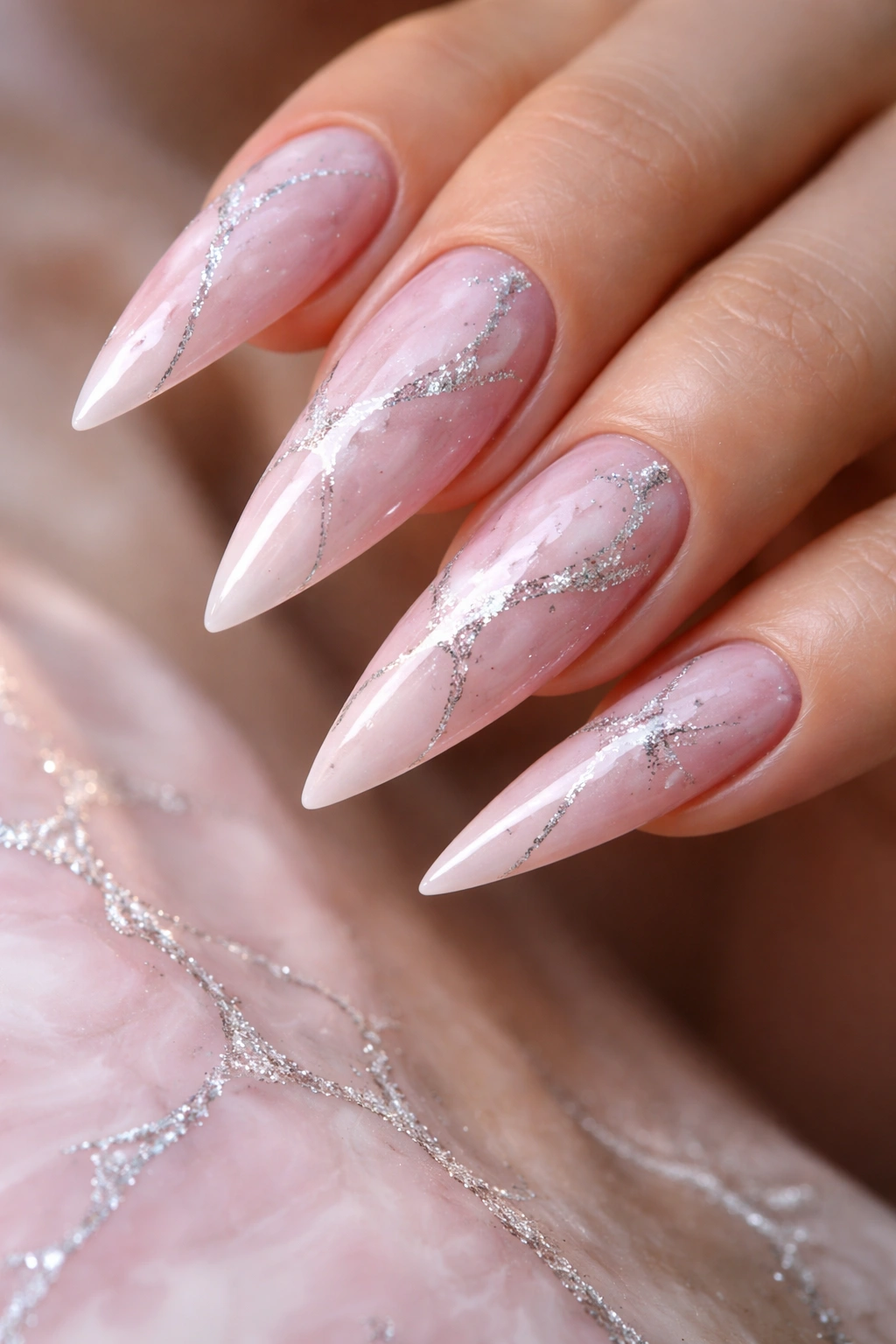 Pink marble nails with silver veining on stiletto shape