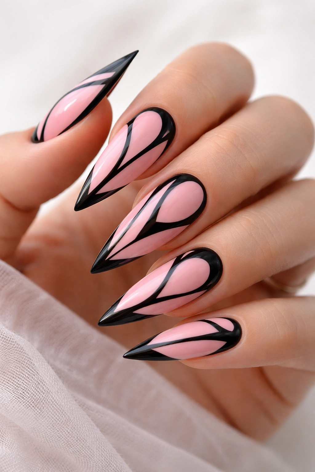 Pink nails with black negative space designs on a hand