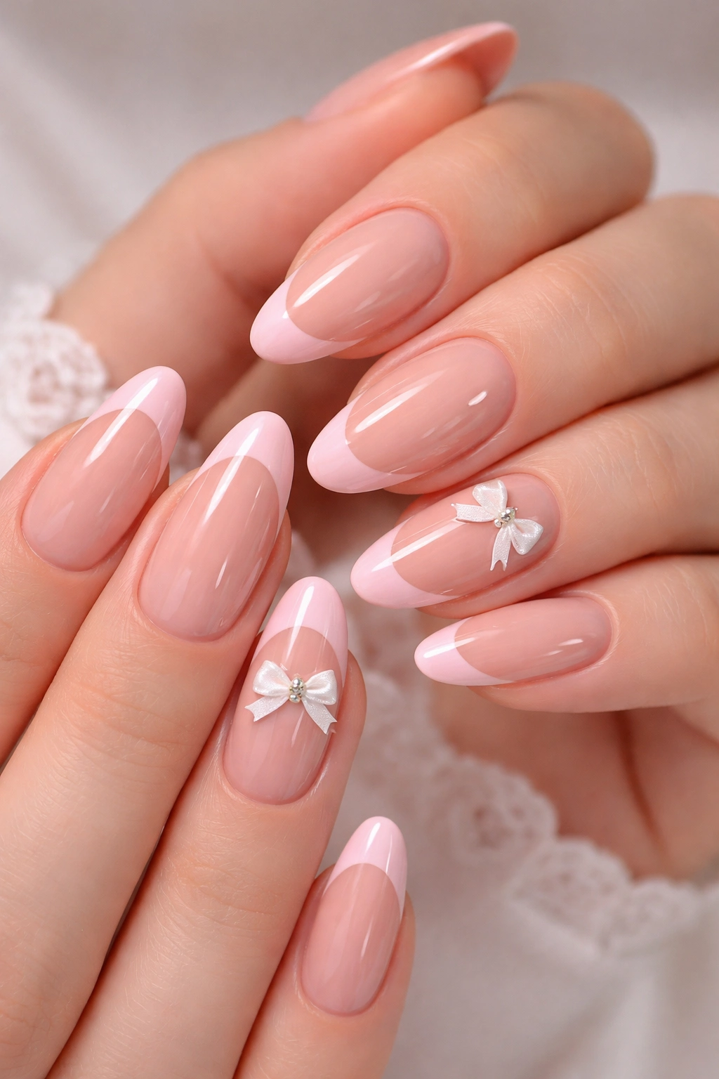 Close-up of classic pink French tips with dainty bows on nails