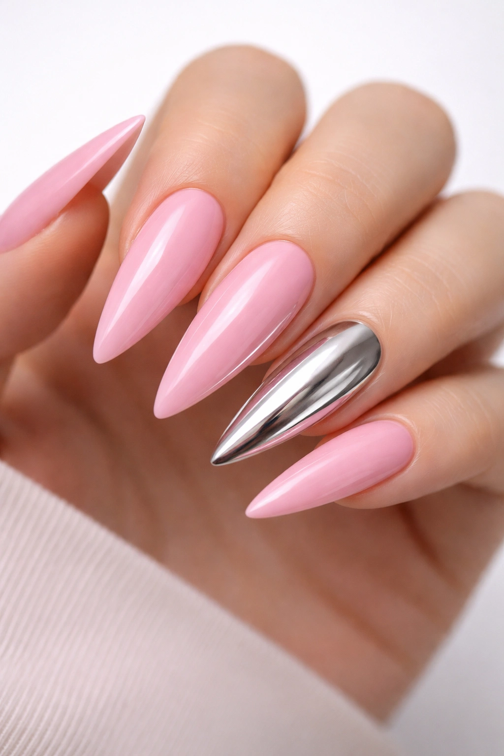 Bubblegum pink stiletto nails with chrome accents on select nails