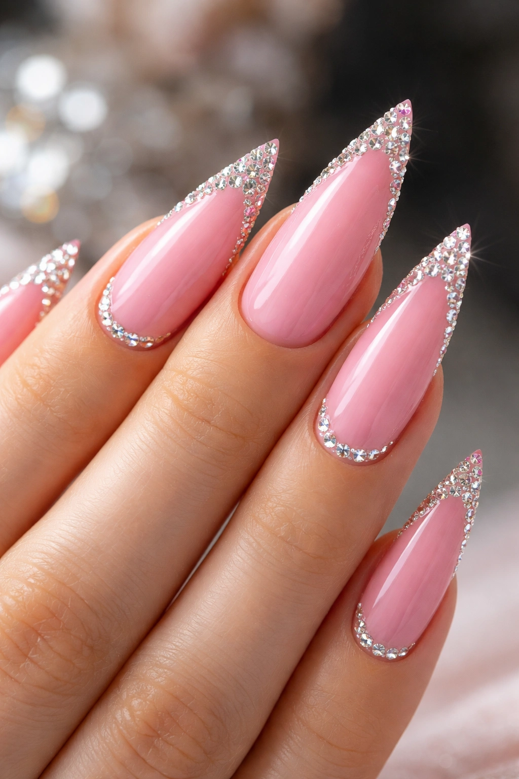 Pink stiletto nails with diamond accents at tips.