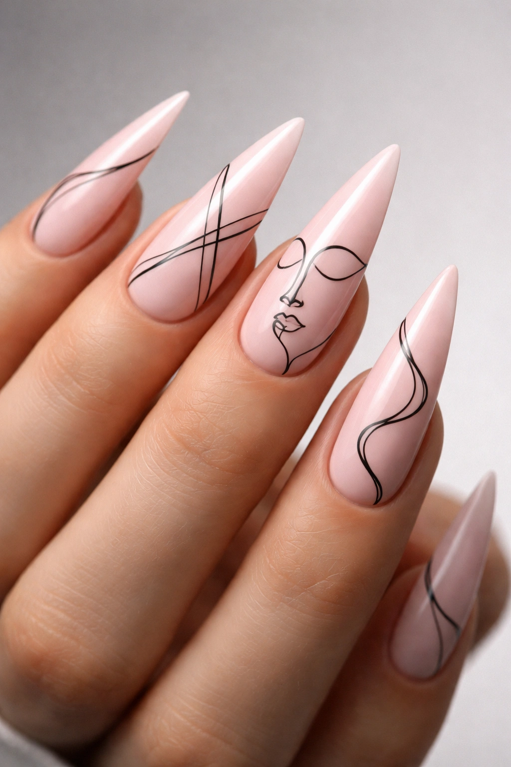 Close-up of pink stiletto nails with ultra-thin black line art on a neutral background
