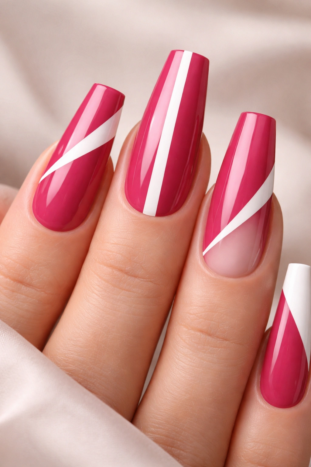 Close-up of deep pink coffin nails with bold white negative-space geometric shapes