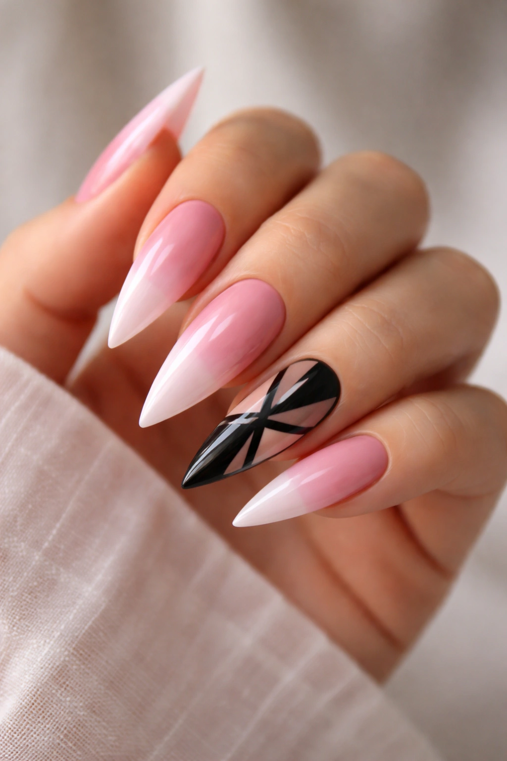 Pink ombré stiletto nails with a black geometric accent nail