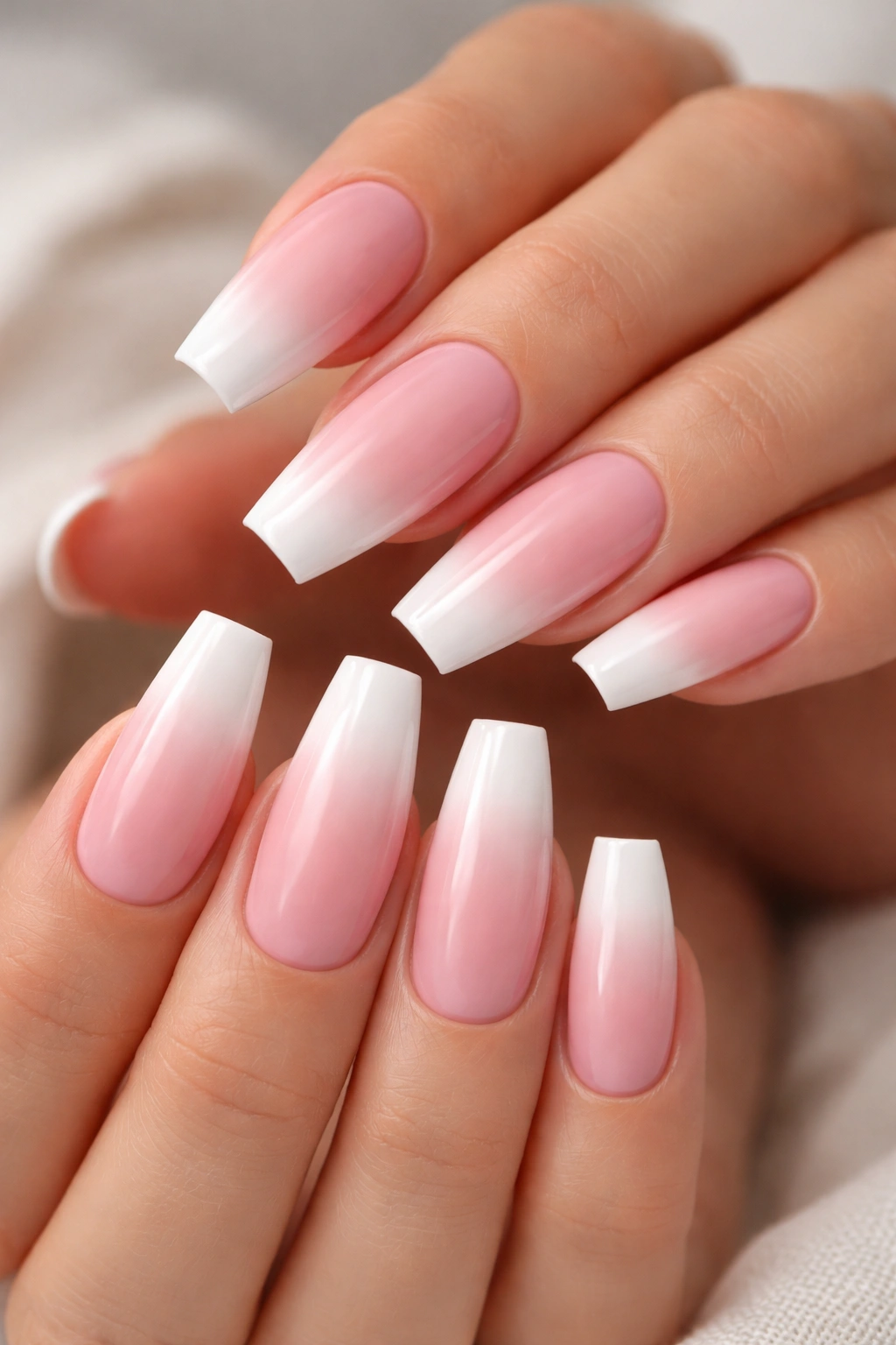 Close-up of coffin nails with pink-to-white ombre and white tips