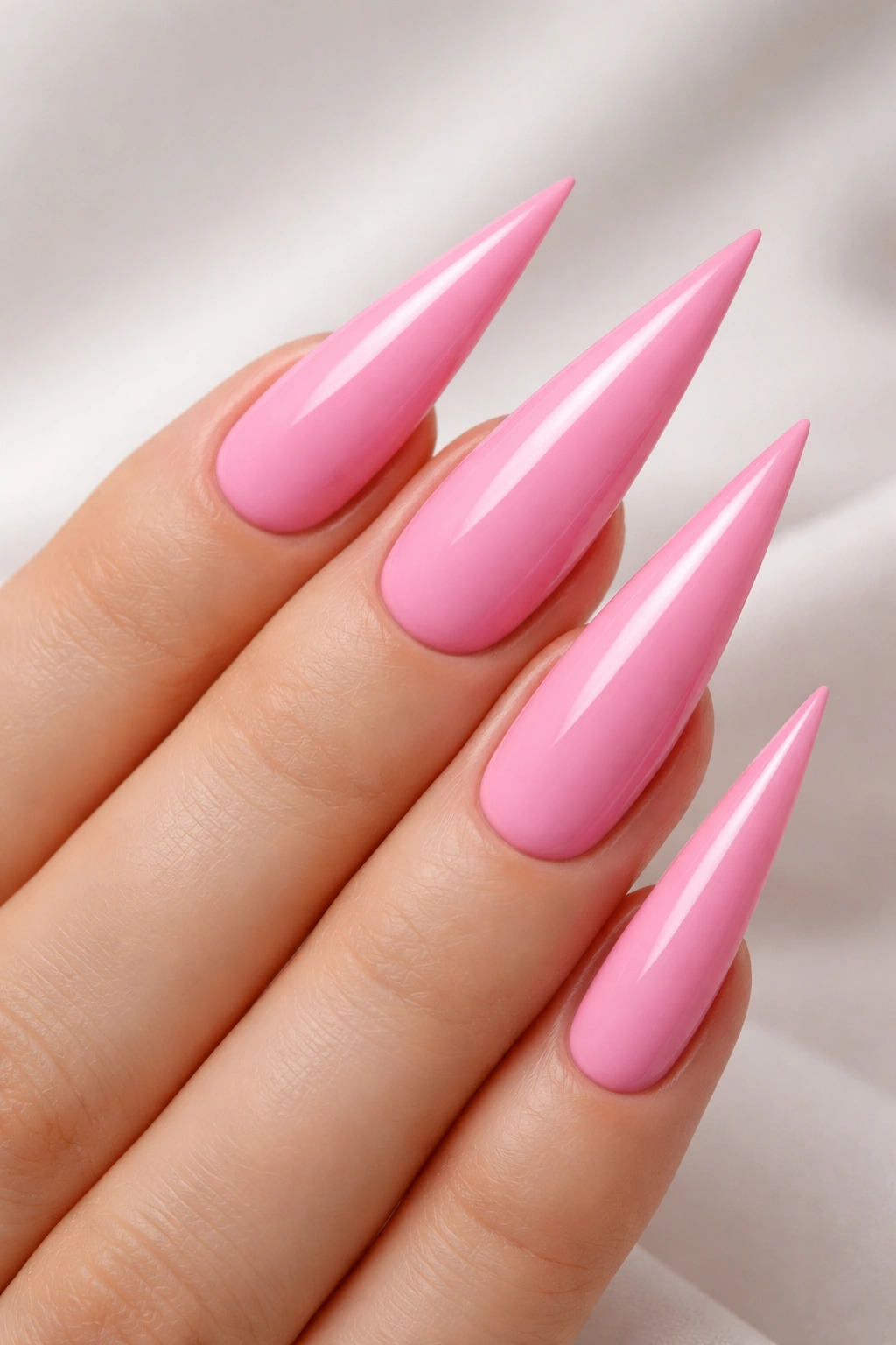 Close-up of pink stiletto nails with pointed tips